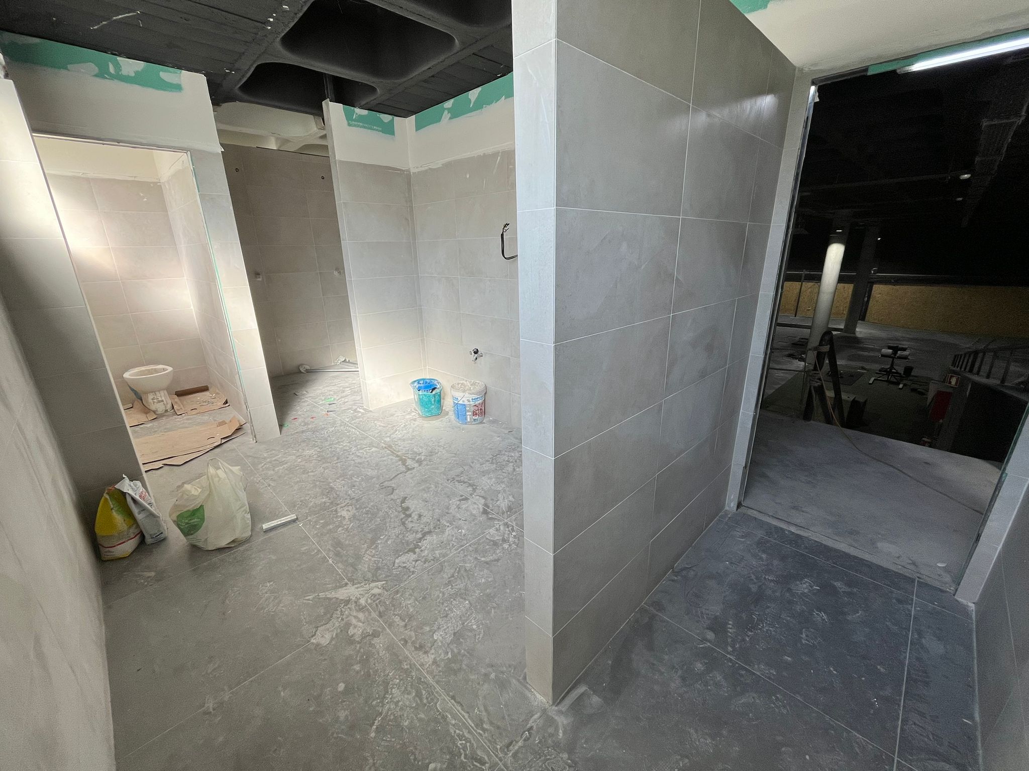 Uma atleta a segurar uma barra em posição de front rack outra a ajudar