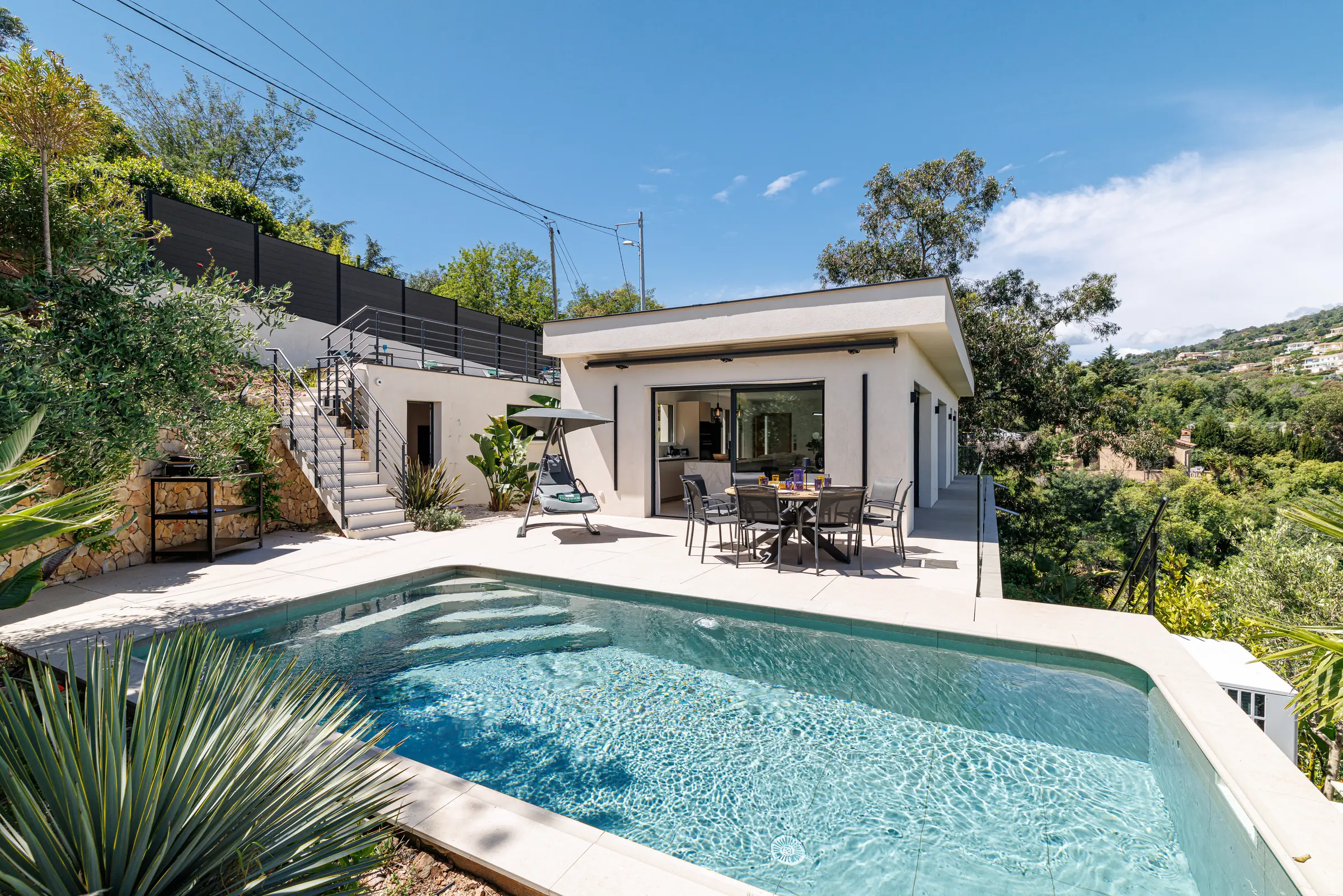 Photographie d'une villa ensoleillée avec piscine.