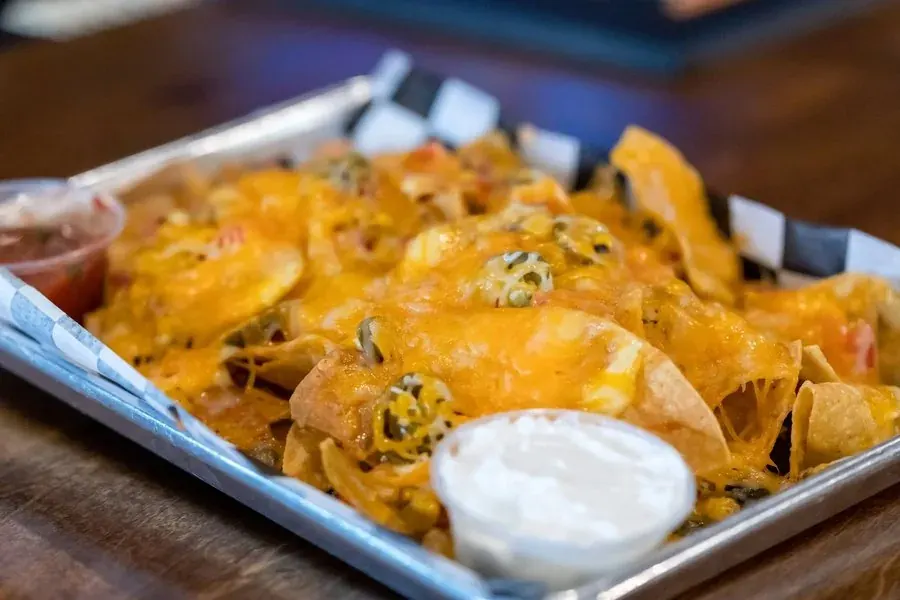 Tray of loaded nachos with sour cream