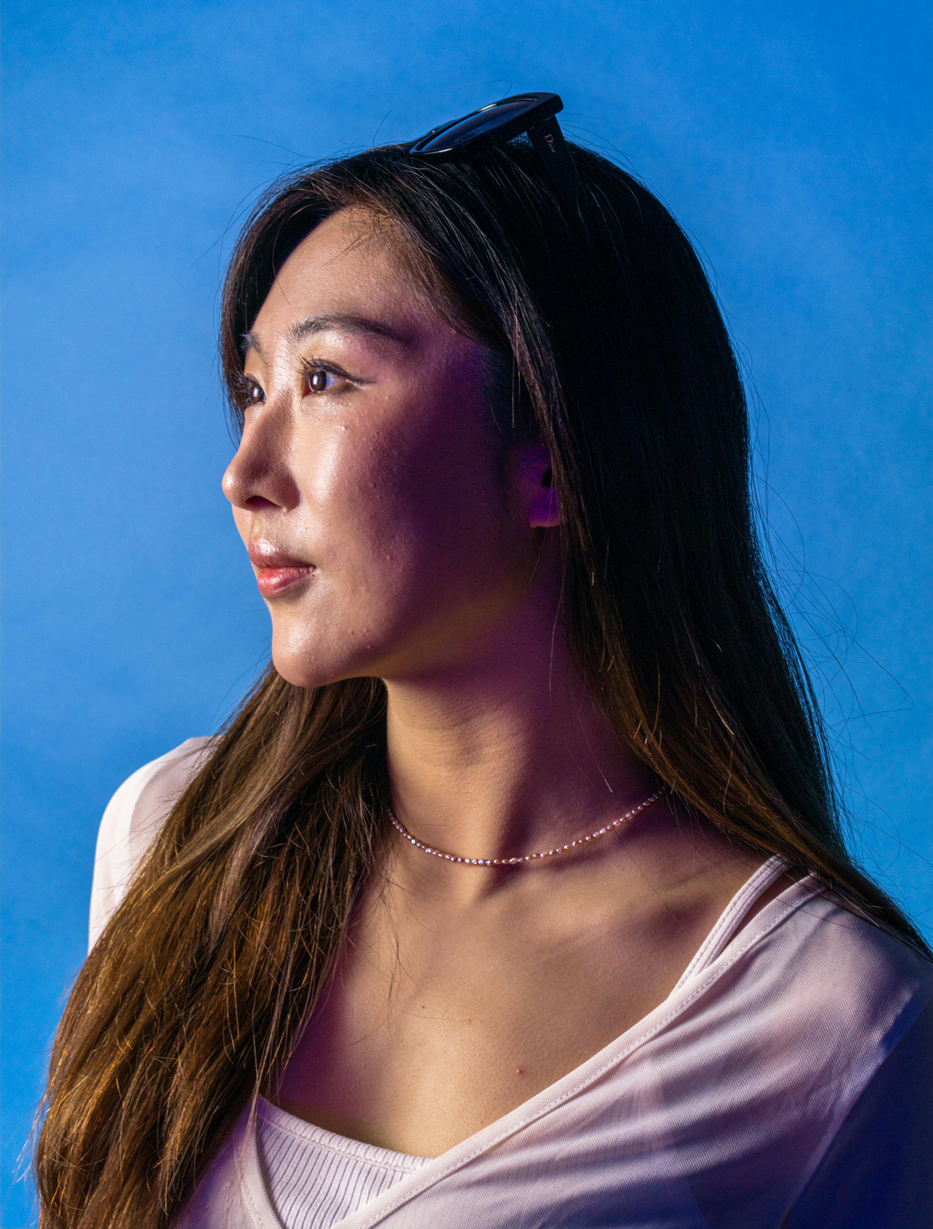 side-profile-portrait-of-a-woman-against-a-blue-background,-highlighting-her-ser - terrance-barksdale (pexels)