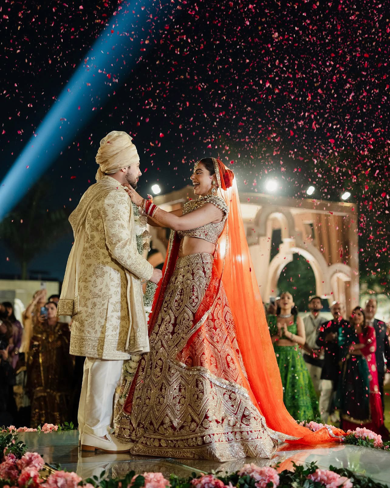 A woman in a wedding dress standing under a floral arch