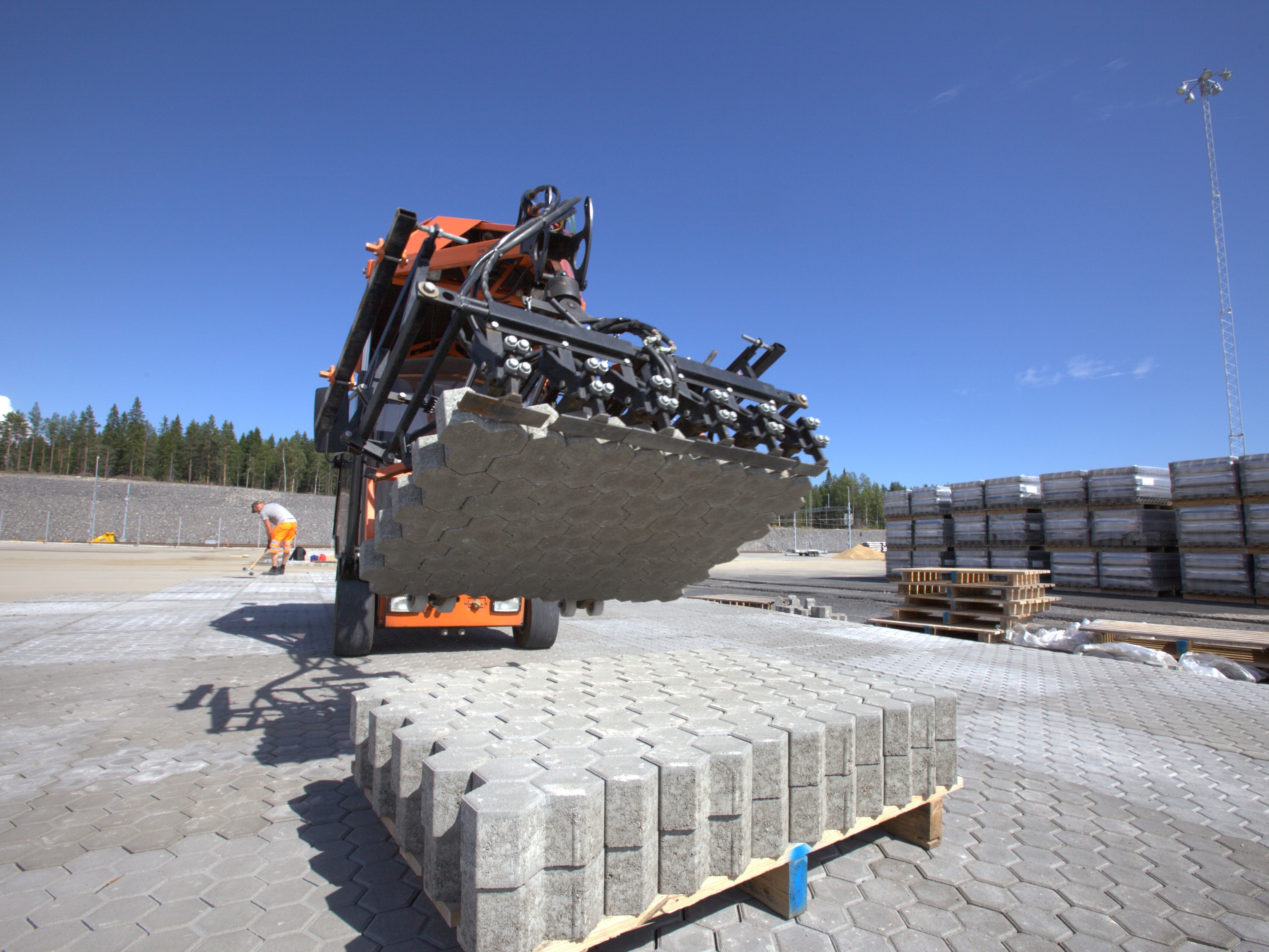 Máquina movendo blocos de pavimentação.