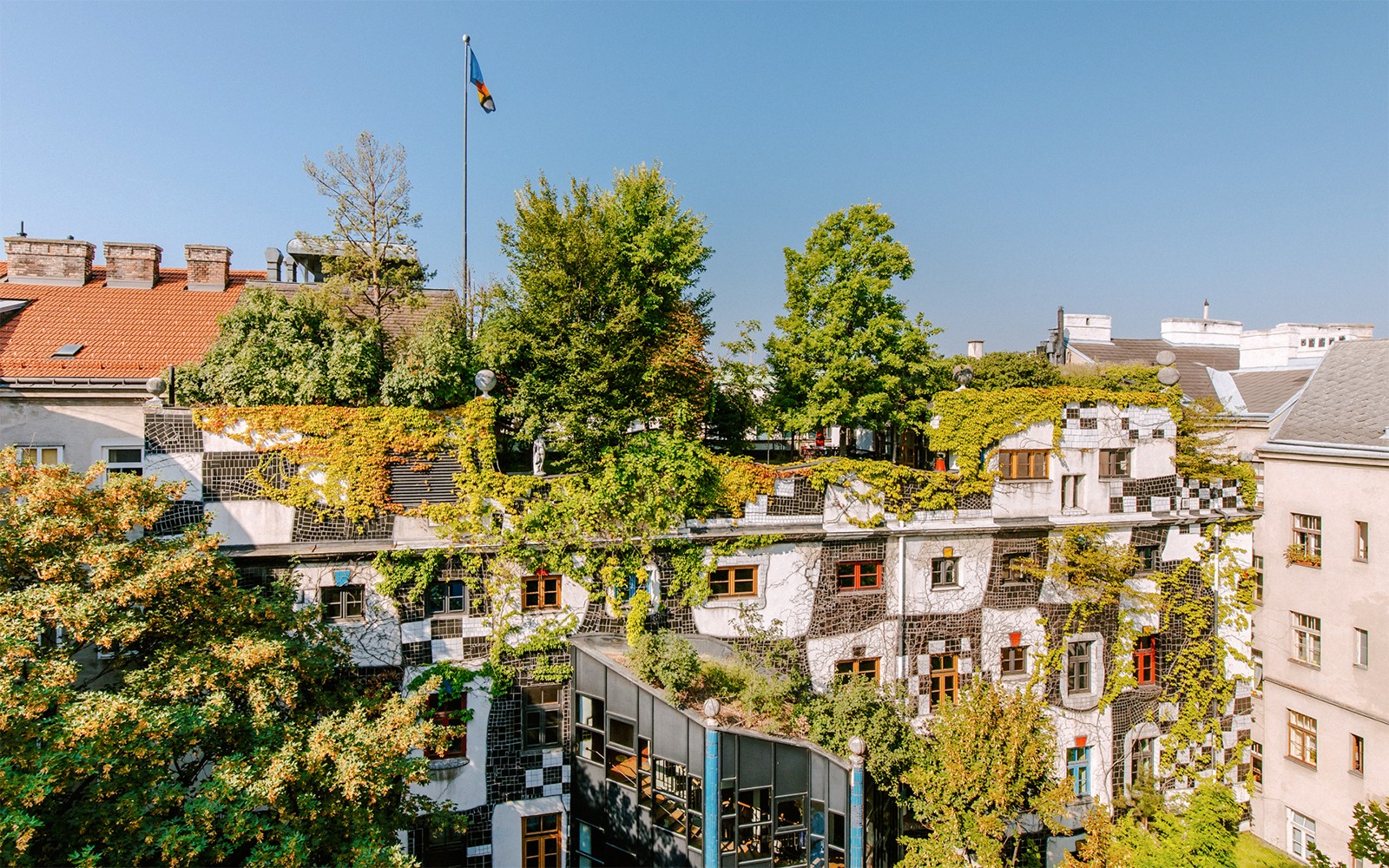 Taman atap KUNST HAUS WIEN dengan tanaman hijau rimbun dan jendela berwarna-warni di Wina.