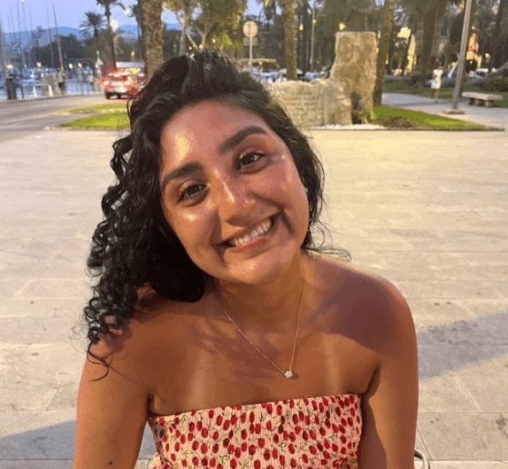 A smiling happy customer with curly hair on a blue background