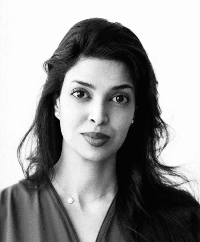 A serene portrait of a person with short dark hair and a silky high-collared outfit, set against a softly blurred background.