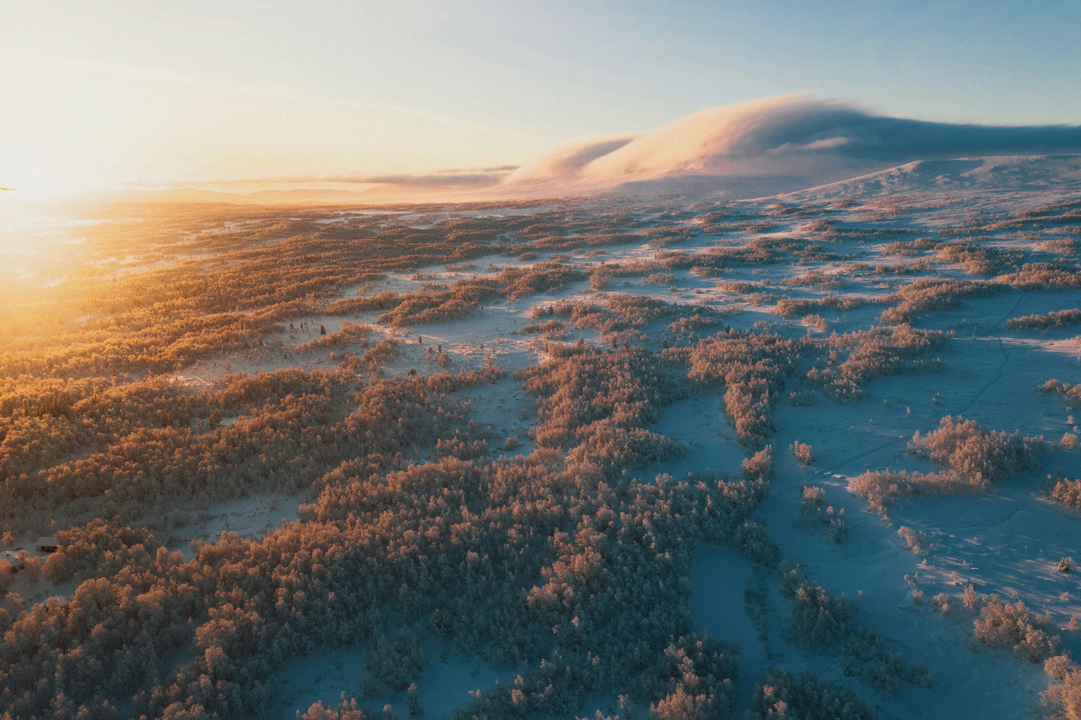 Dronefoto av snødekt landskap i soloppgang