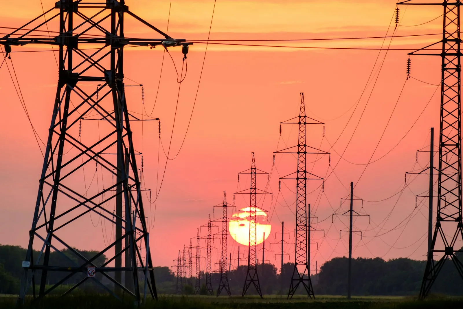 Silhouetted power lines at sunset over Kansas plains