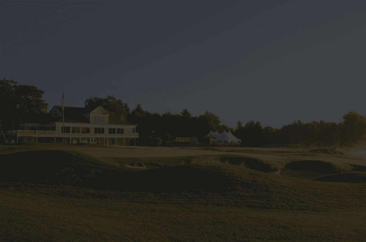 Golf clubhouse at golden hour with a putting green in the foreground