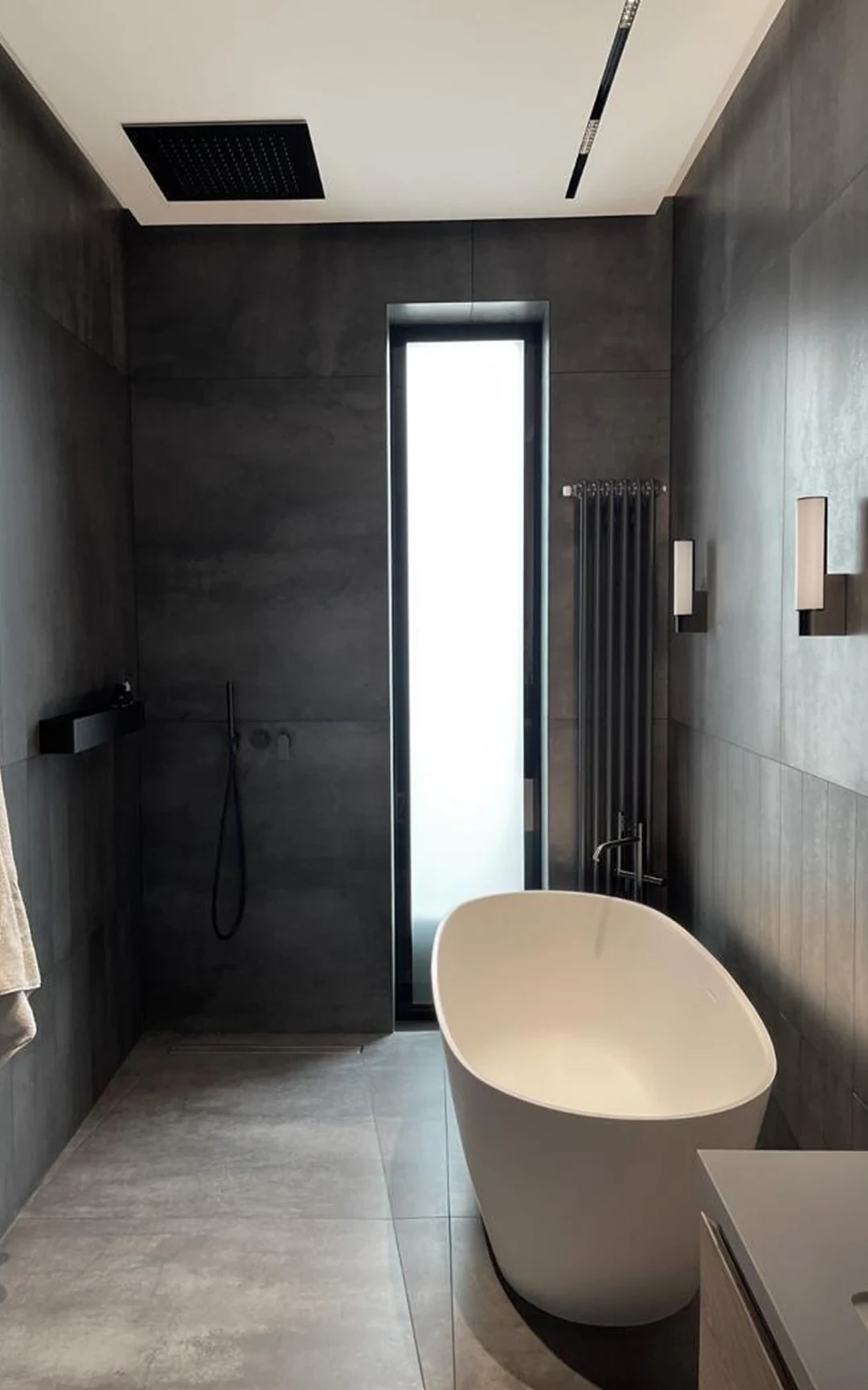 Salle de bains — robinetterie noire mate et paroi vitrée.