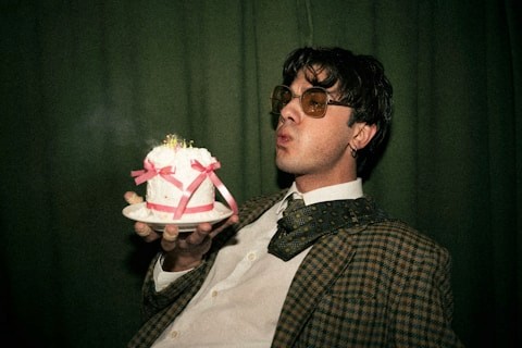 Man holding bouquet of flowers against green background