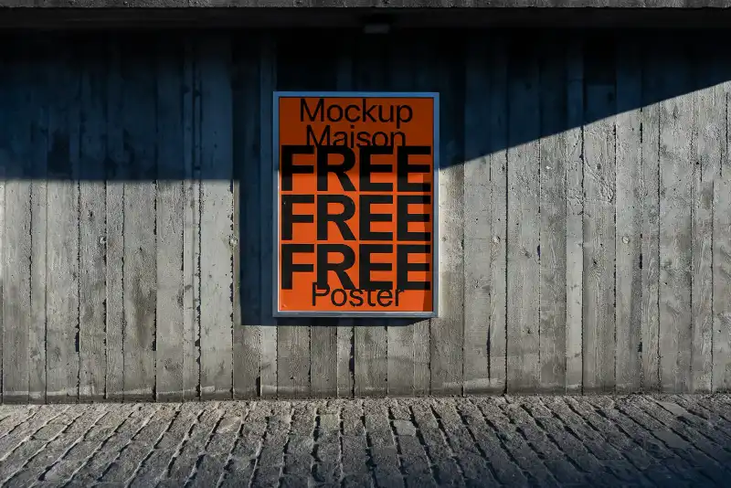 Framed poster mockup mounted on a rugged concrete wall, illuminated by partial sunlight. The bright blue design contrasts sharply with the industrial gray tones, creating a modern urban display.