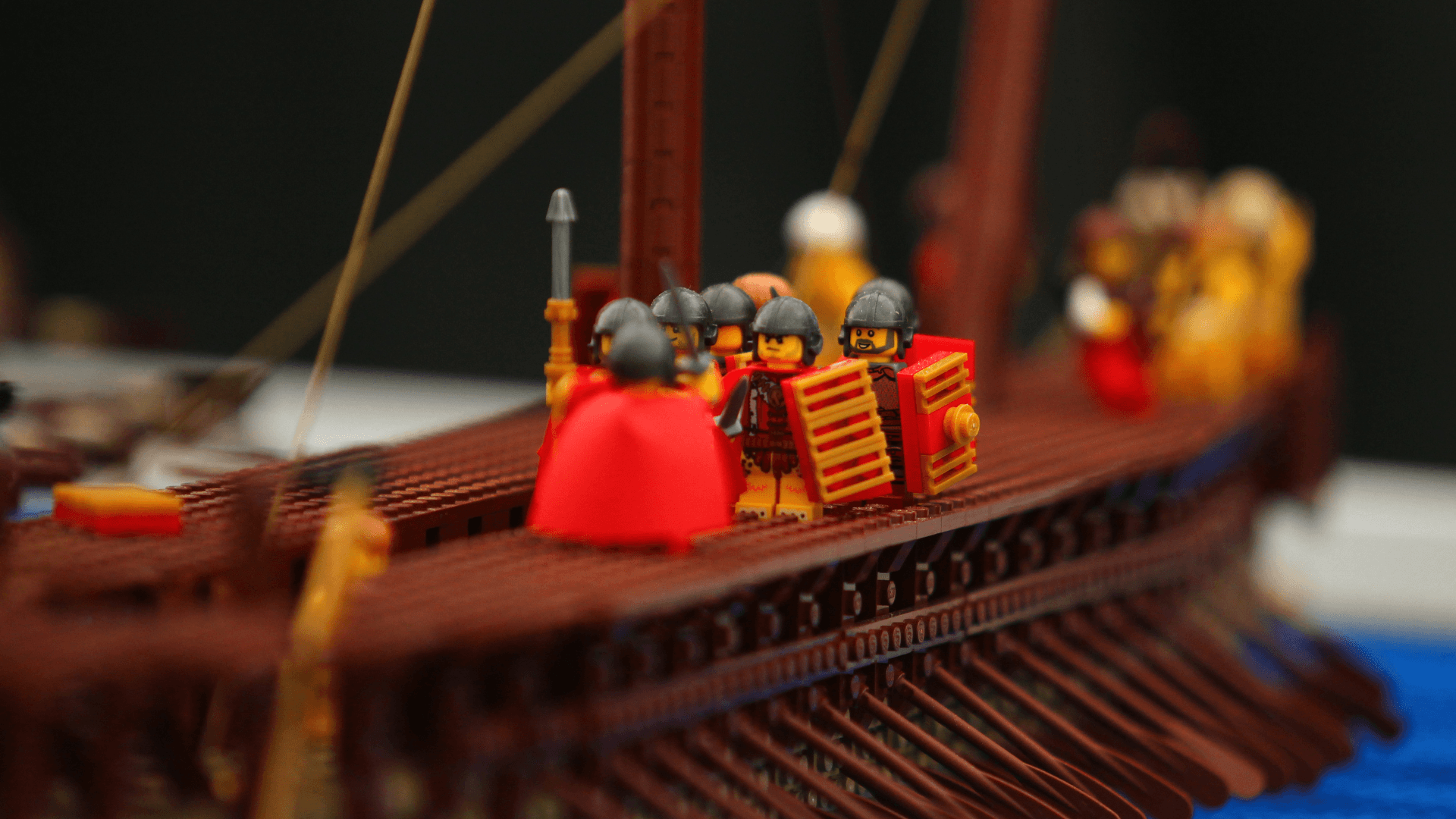 Eight LEGO® Greek soldiers stand on top of a Greek Trireme ship.