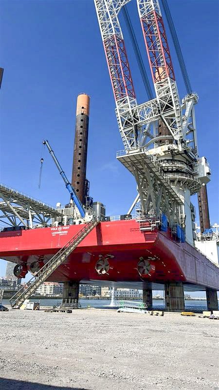 CASC employee inspecting wind turbine nacelles staged on supports at a port facility