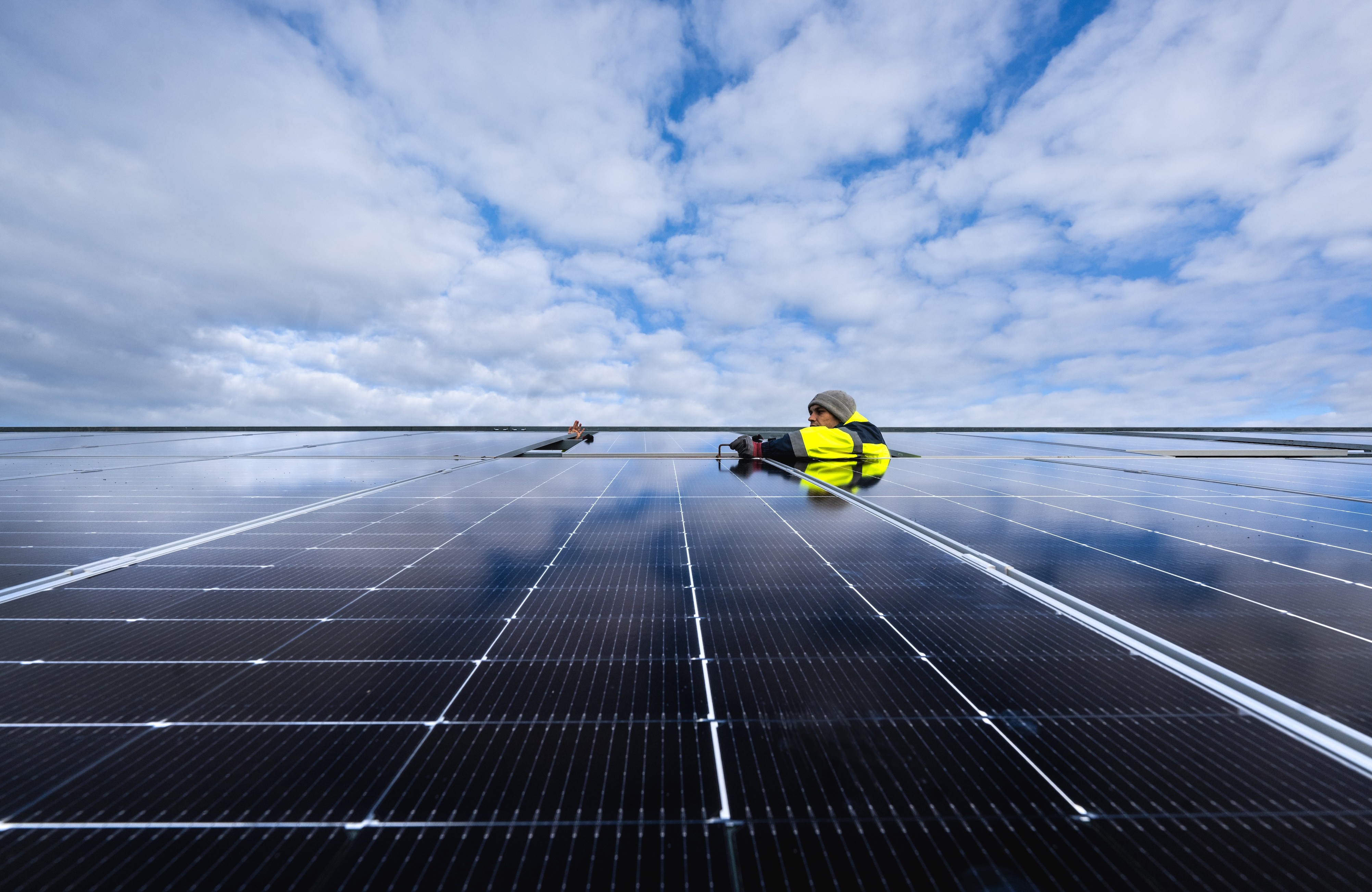 Blick auf Arbeiten an Photovoltaikmodulen im Hybriden Energiepark Sande