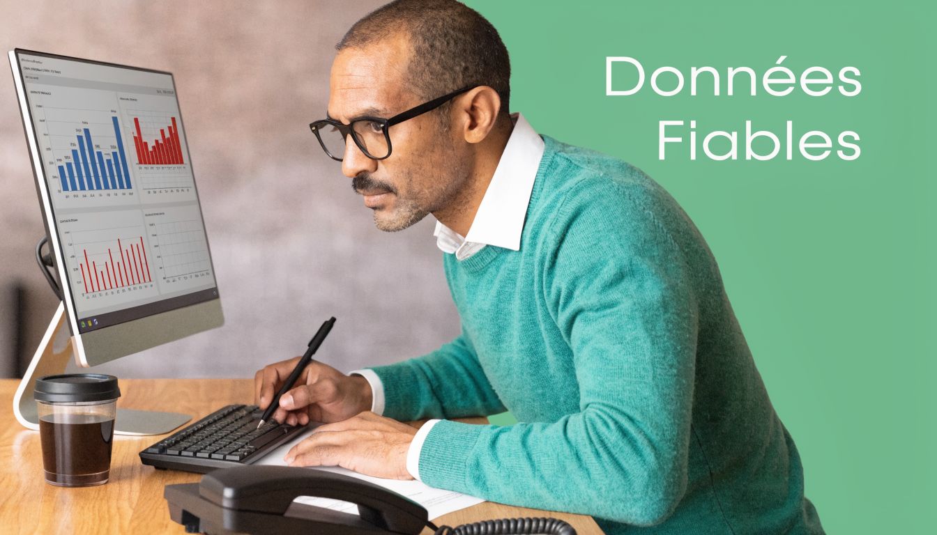 Un homme d'affaires concentré analyse des graphiques de données sur son ordinateur de bureau avec une tasse café.