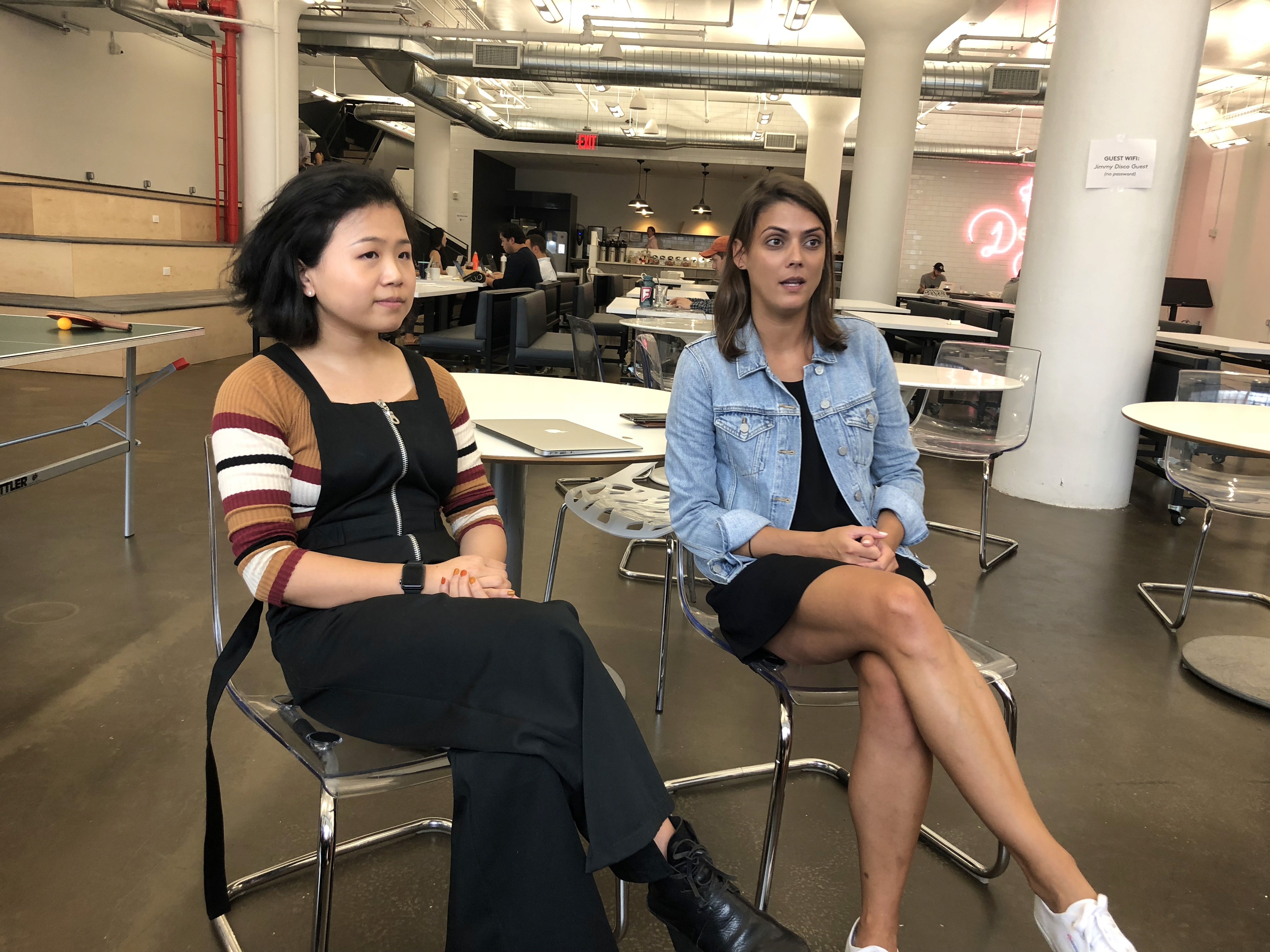 A photo of two girls sitting close to each other on chairs.