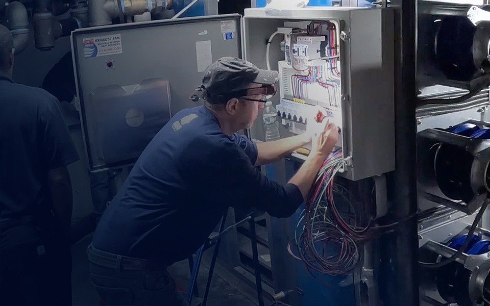 GRR Cooling Experts technician performing HVAC system balancing, commissioning, and control panel integration in a commercial facility.