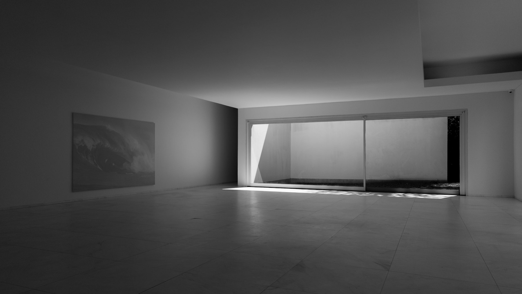 Empty apartment interior with daylight entering through tall glass doors