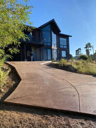 Stained concrete driveway leading to a modern home
