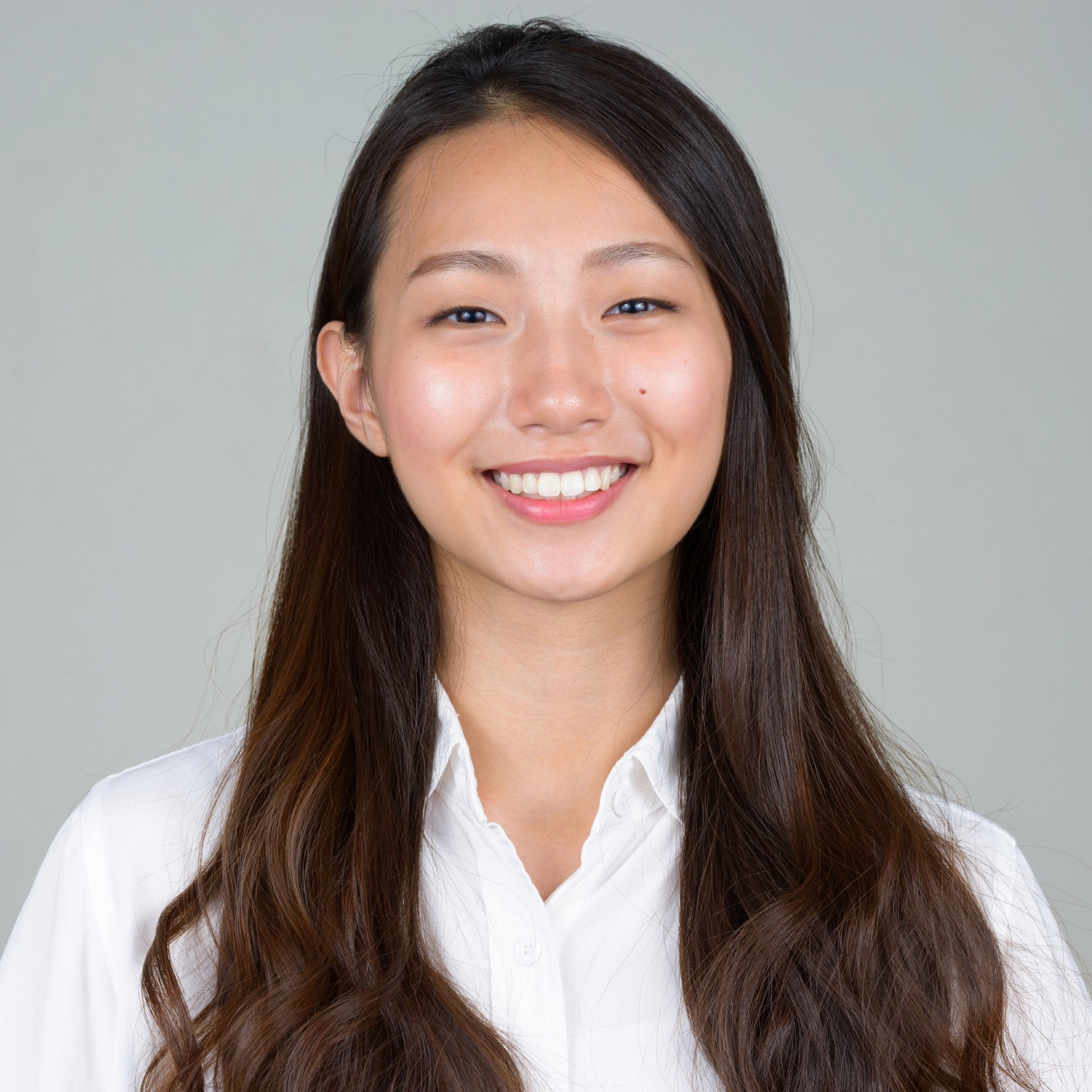 香港商業保險服務專業女顧問，穿著白色襯衫展現親切笑容，為中小企提供獨立保障方案。
