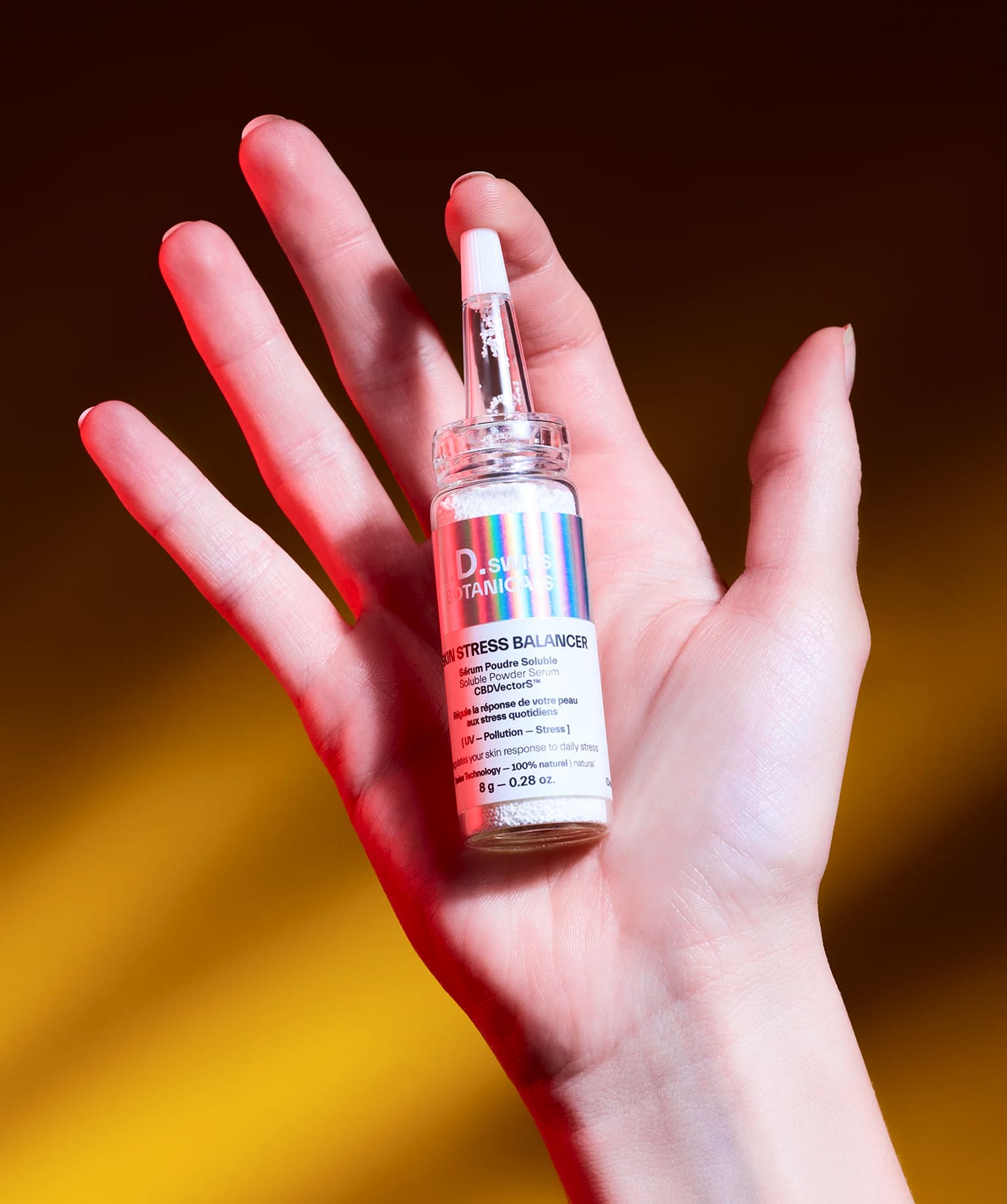 I.D. Swiss Botanicals serum product held in hand with bold lighting emphasizing premium skincare design and campaign art direction