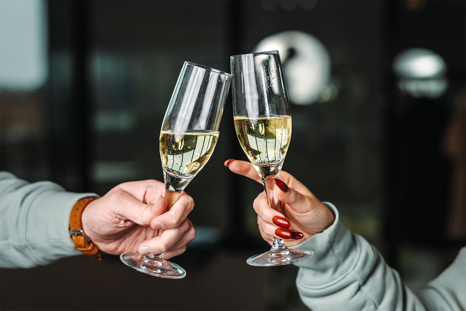 Deux mains trinquant avec des verres de champagne
