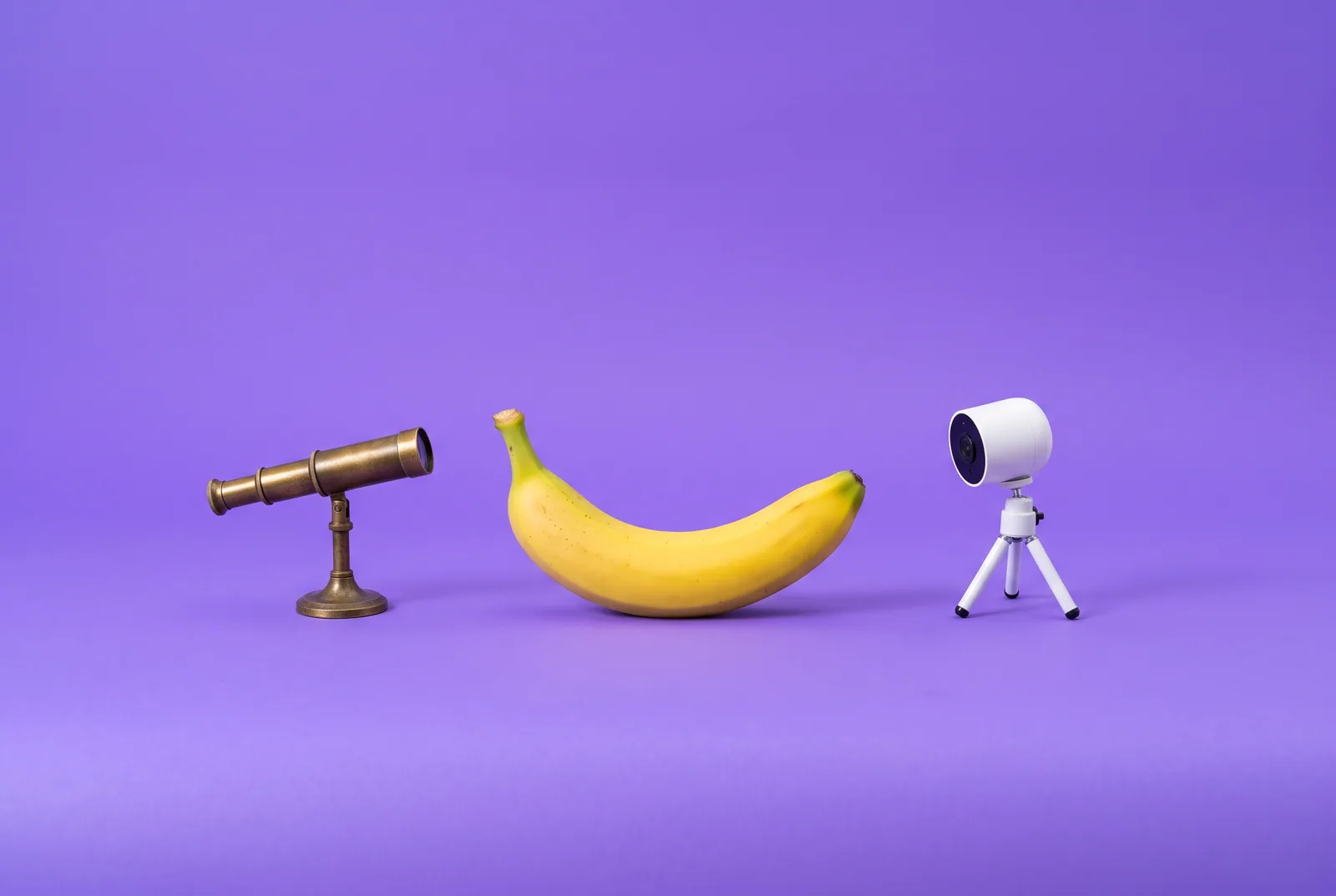 Accountable2You vs Covenant Eyes concept: a banana between a small brass spyglass and a tiny white security camera
