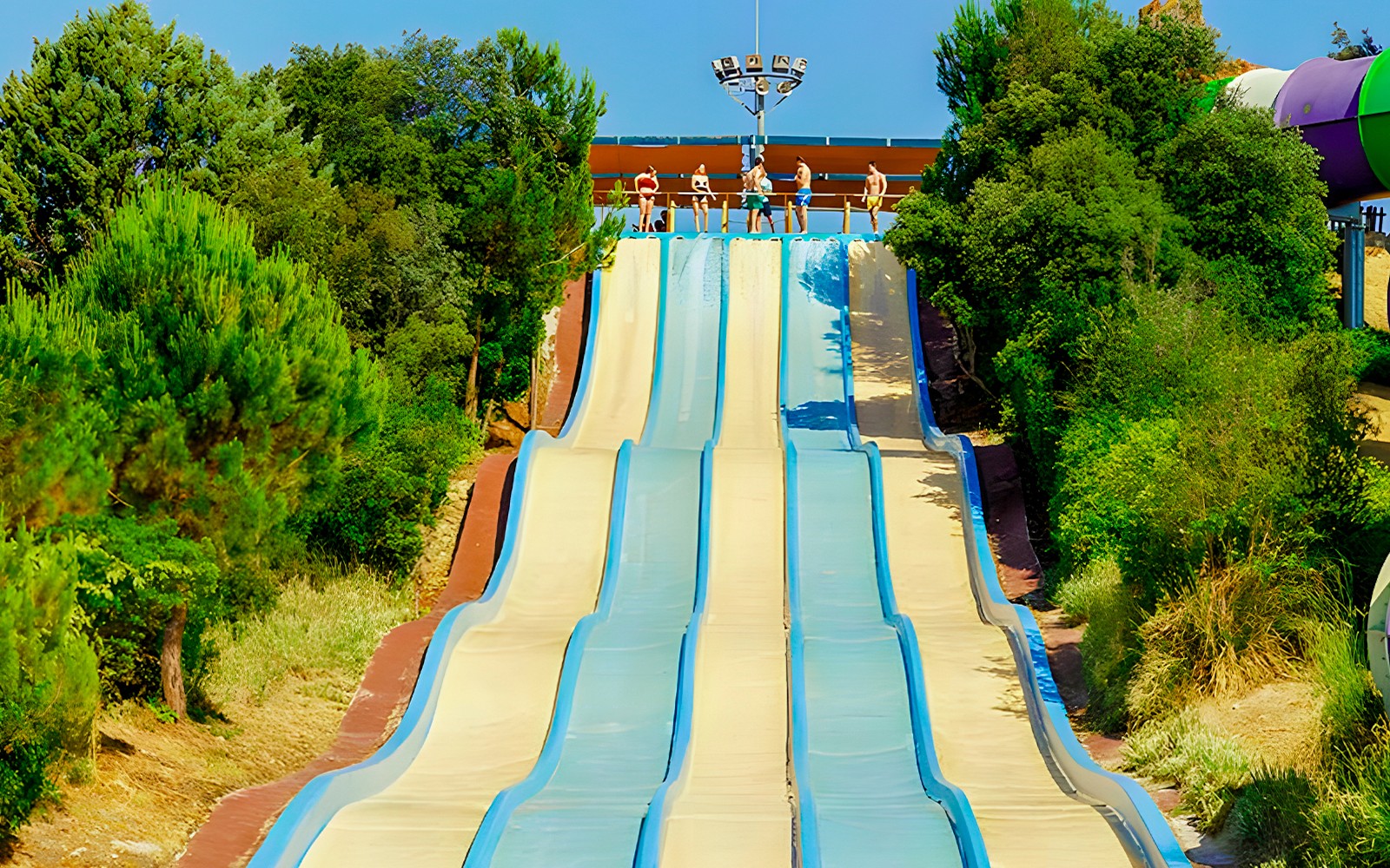 Water slides at Aquopolis Villanueva de la Cañada surrounded by trees.