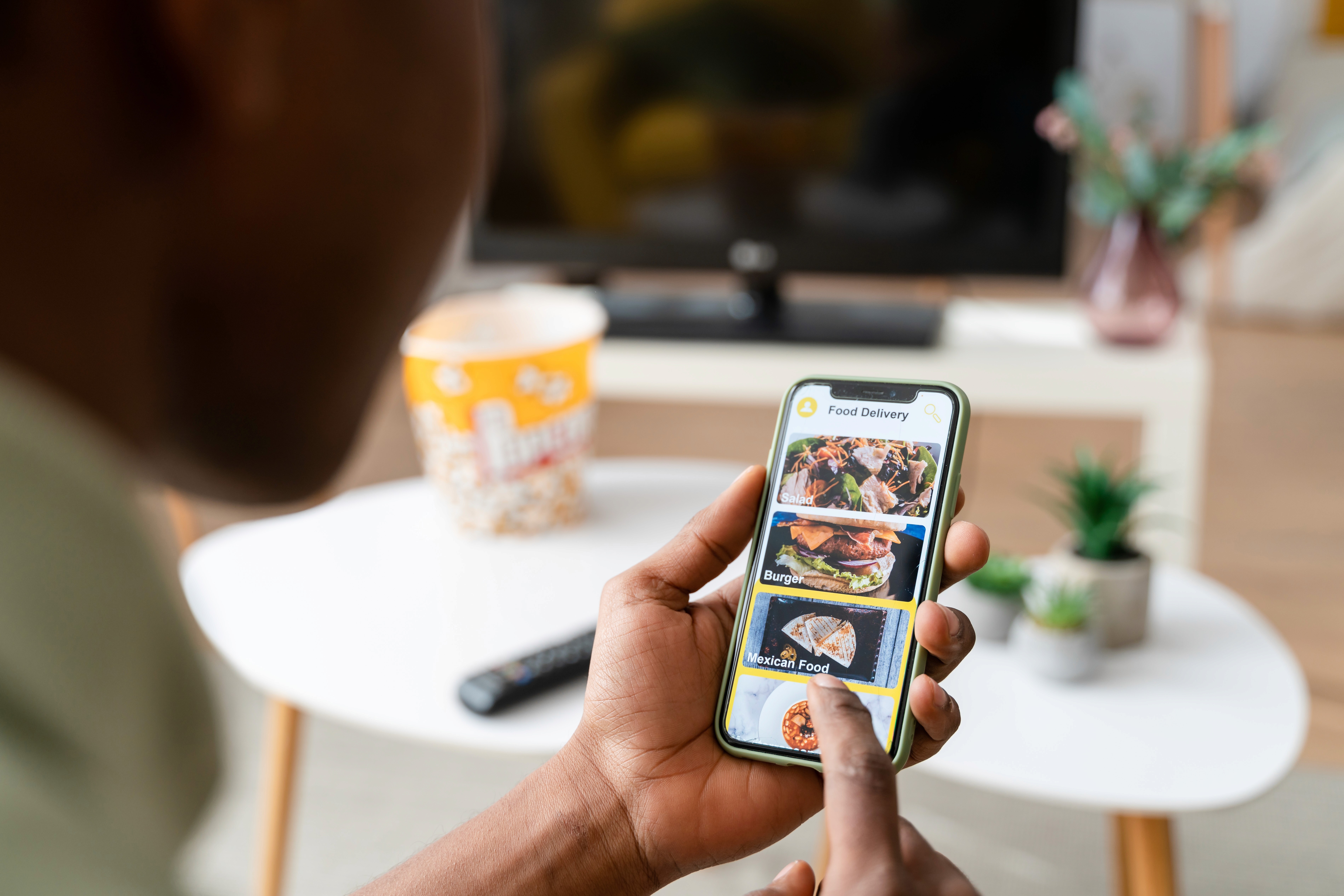 A woman using a phone to set up her ad creative on a mobile application.