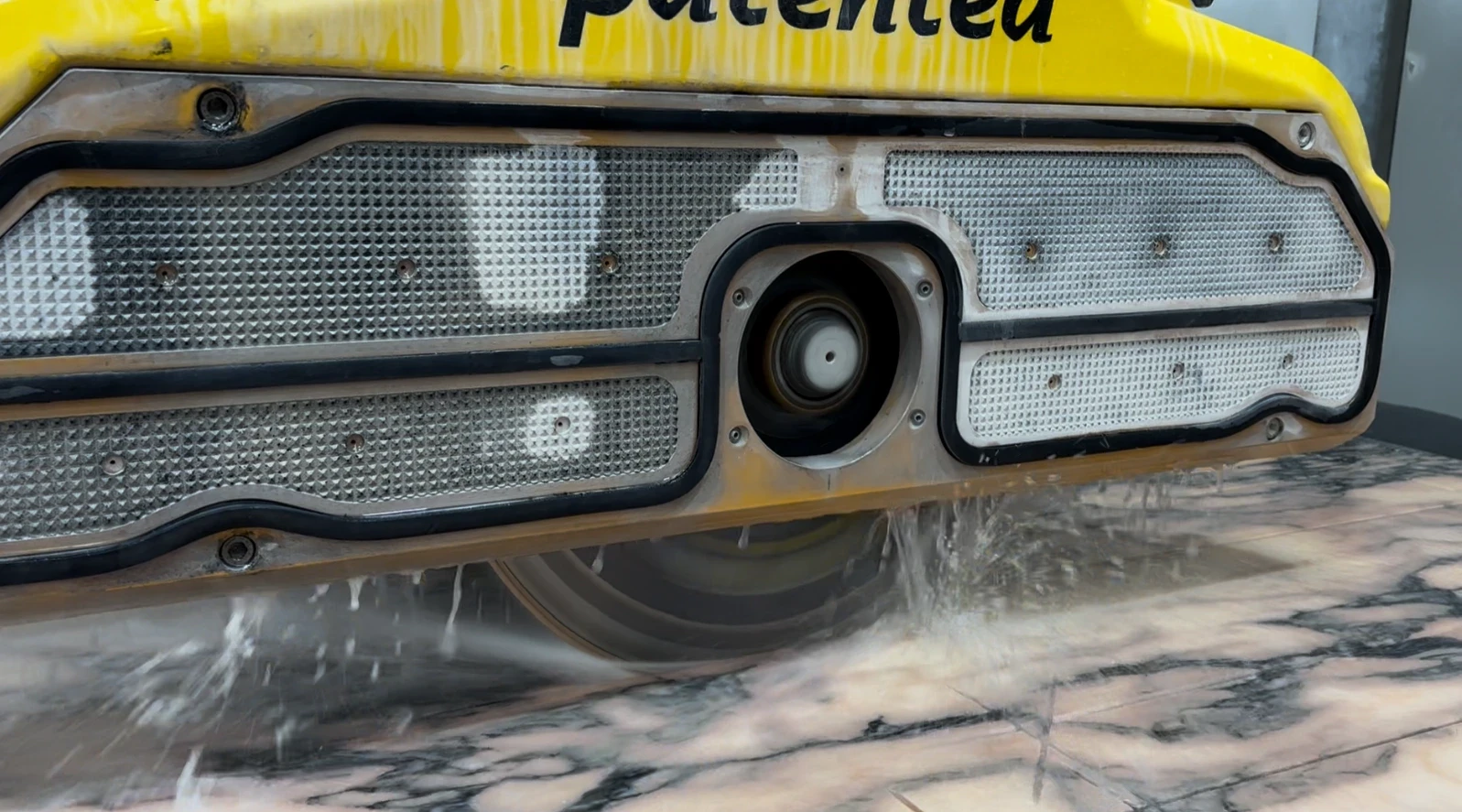 Bridge saw blade cutting a marble slab under water in the Caruso Group workshop