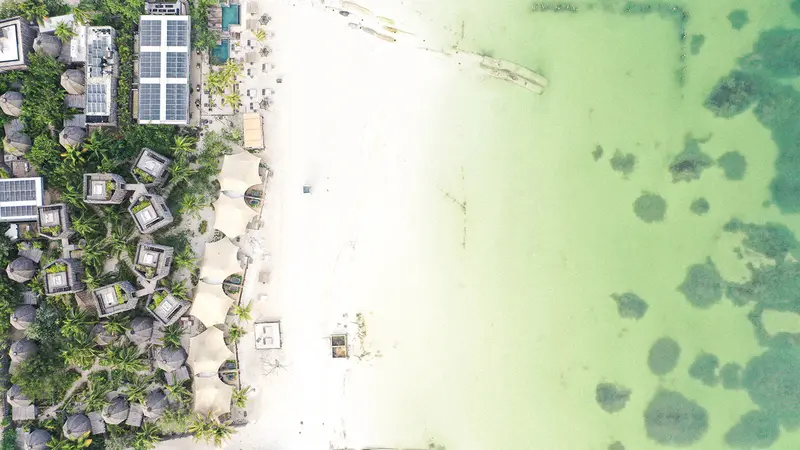 Aerial view of Nomade Holbox, showcasing its oceanfront location and lush tropical surroundings