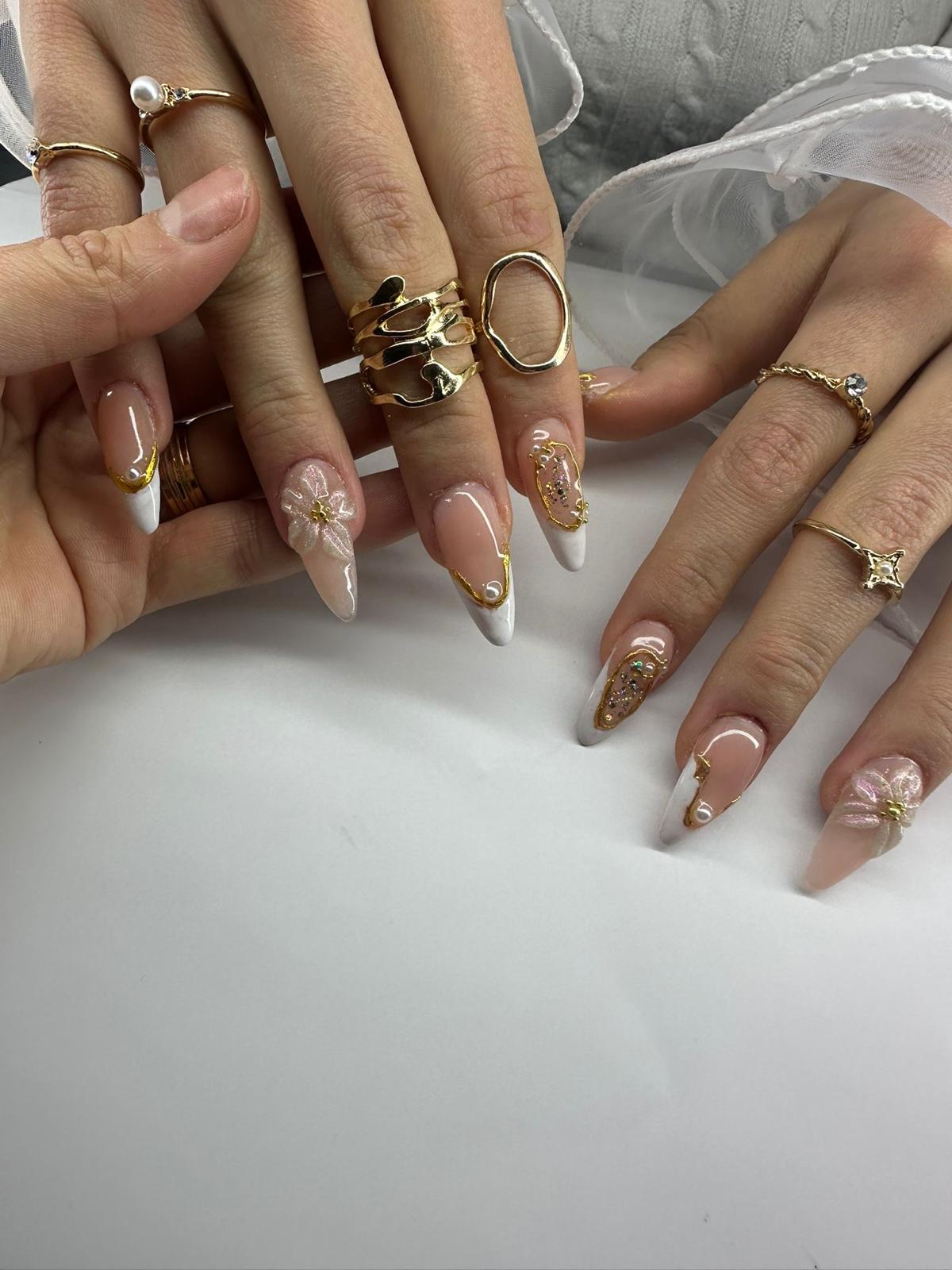 Hand with nude nails wearing a diamond ring, holding a book