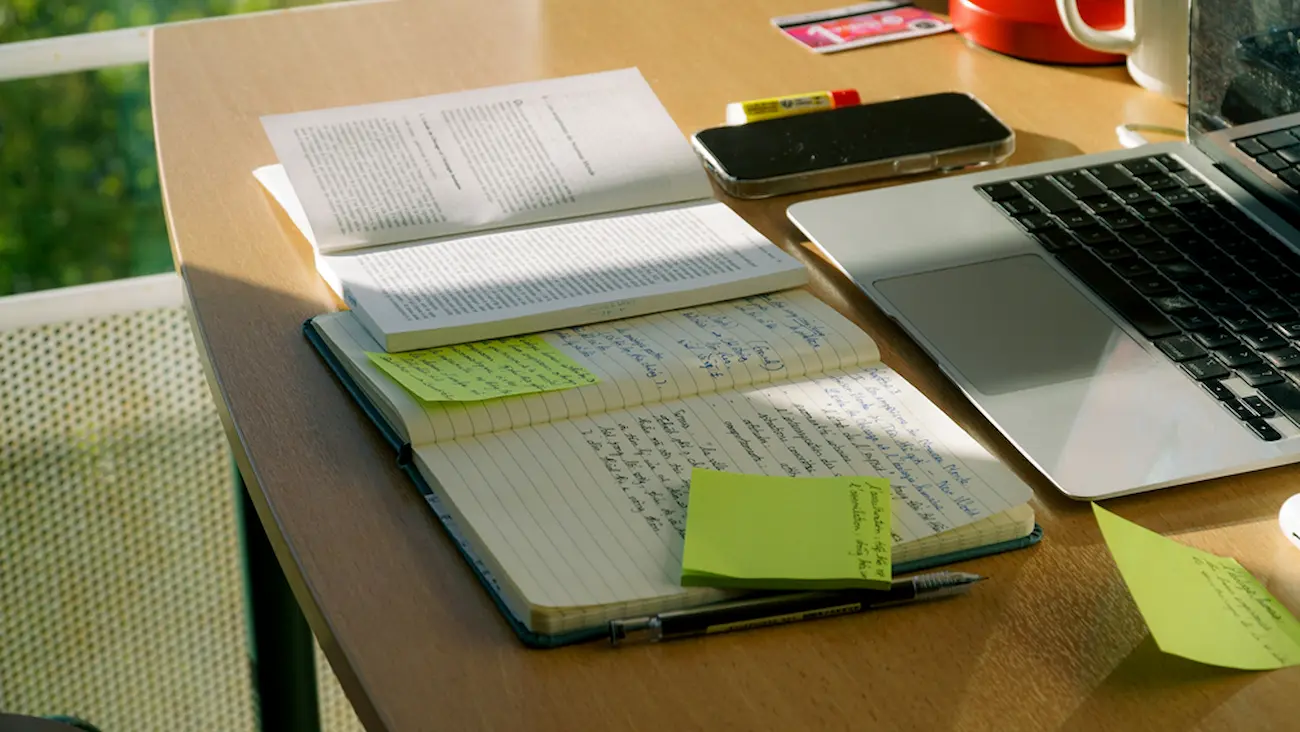 Desk with a laptop and handwritten notes, symbolizing comparing AI tools and lawyer help.
