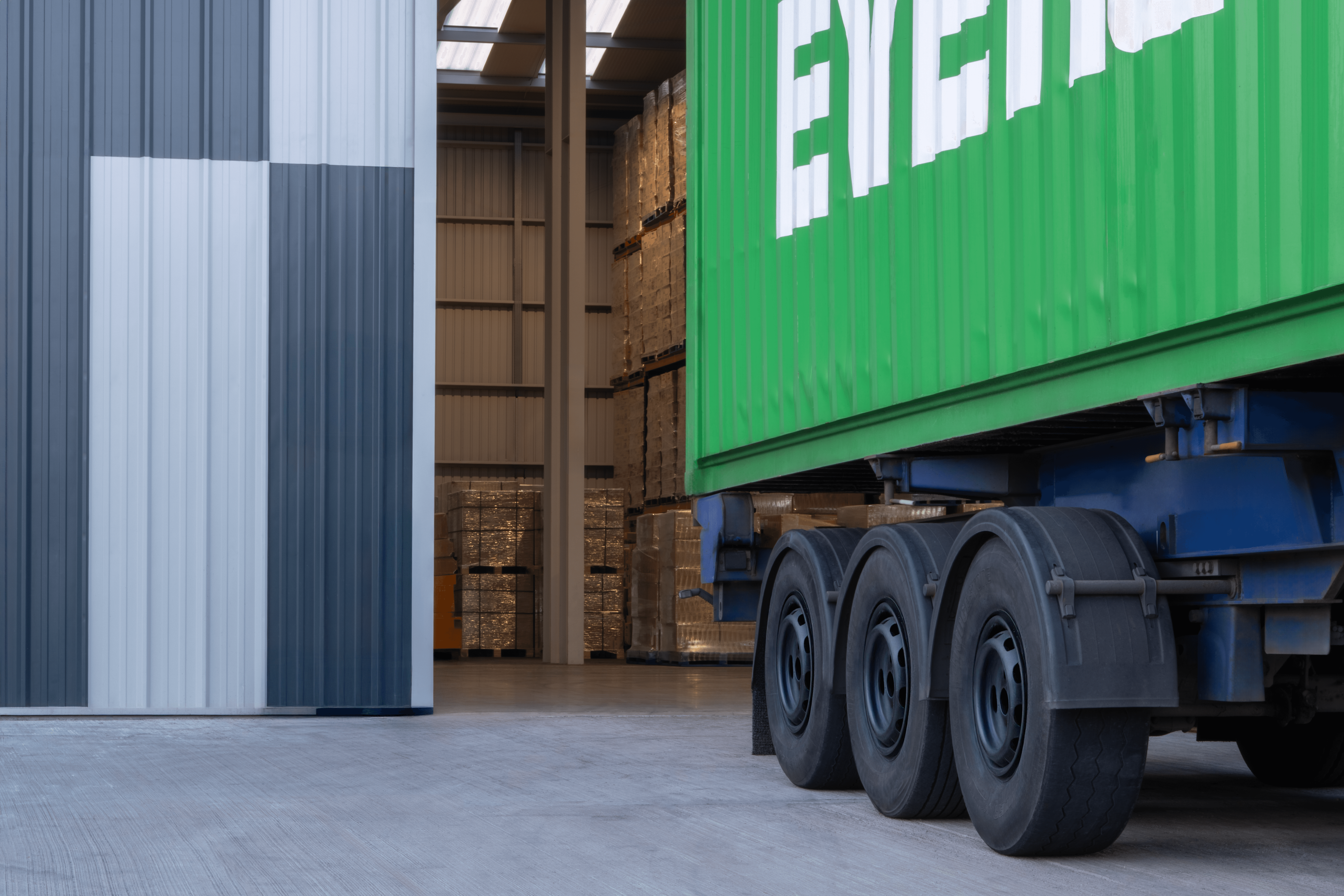 green-truck-parked-in-front-of-warehouse