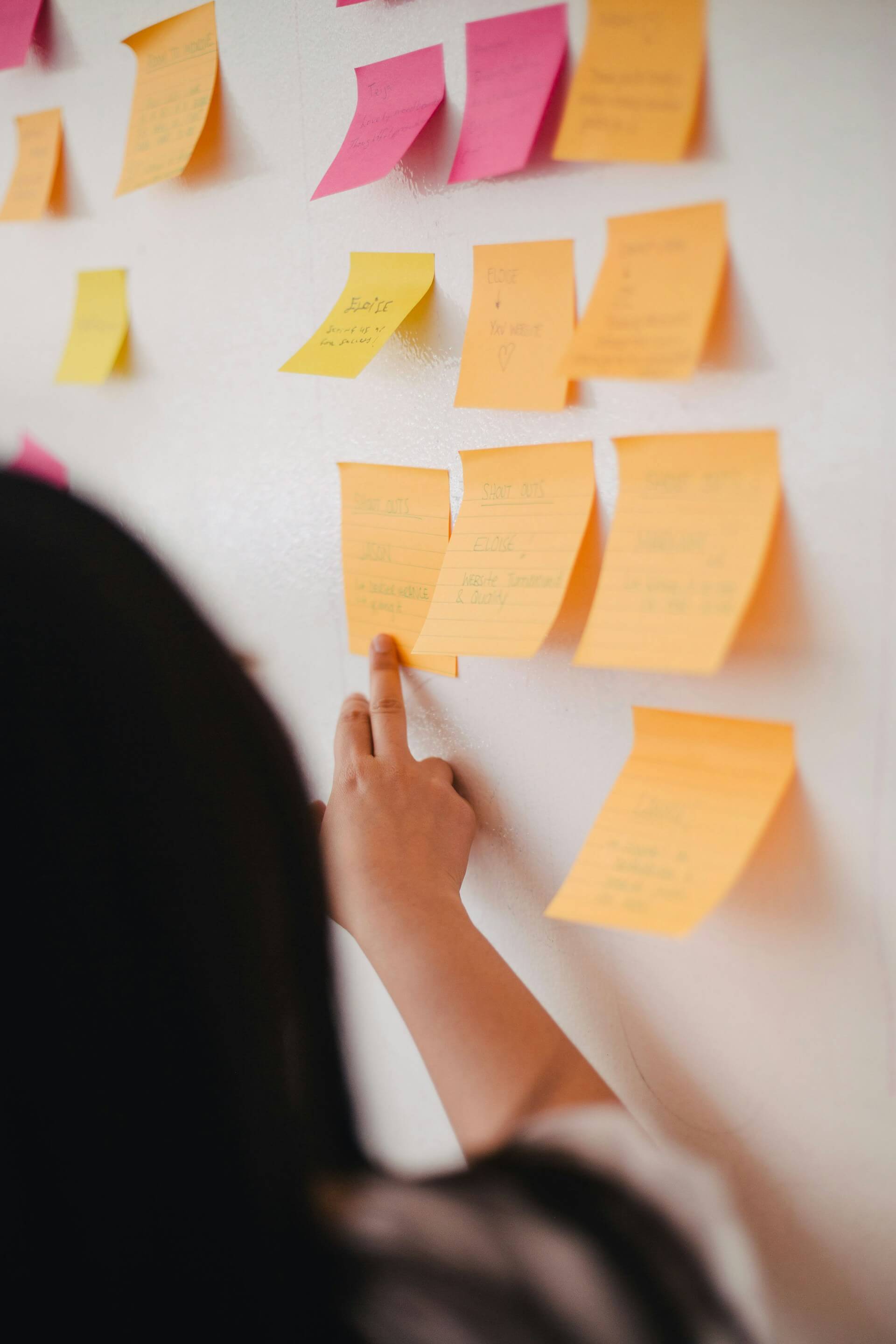 Mulher checando post its no mural