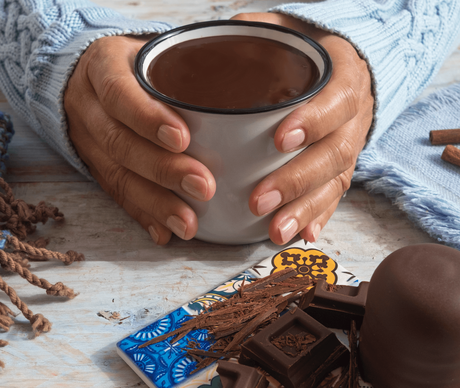 A person with curly hair sits at a desk, working on a laptop in a cozy, well-lit environment.