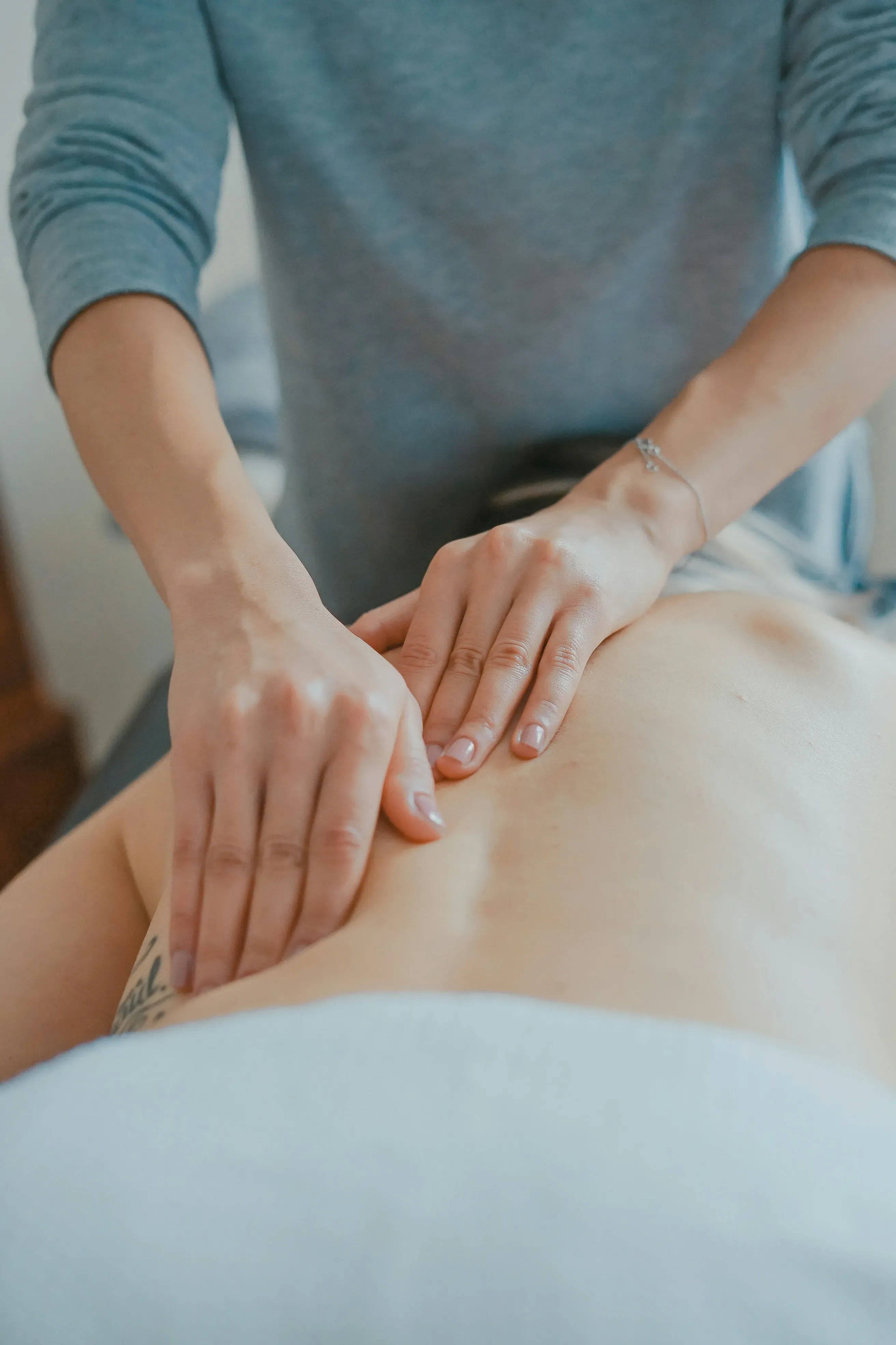 A massage therapist applies pressure to a client's back during a massage session.