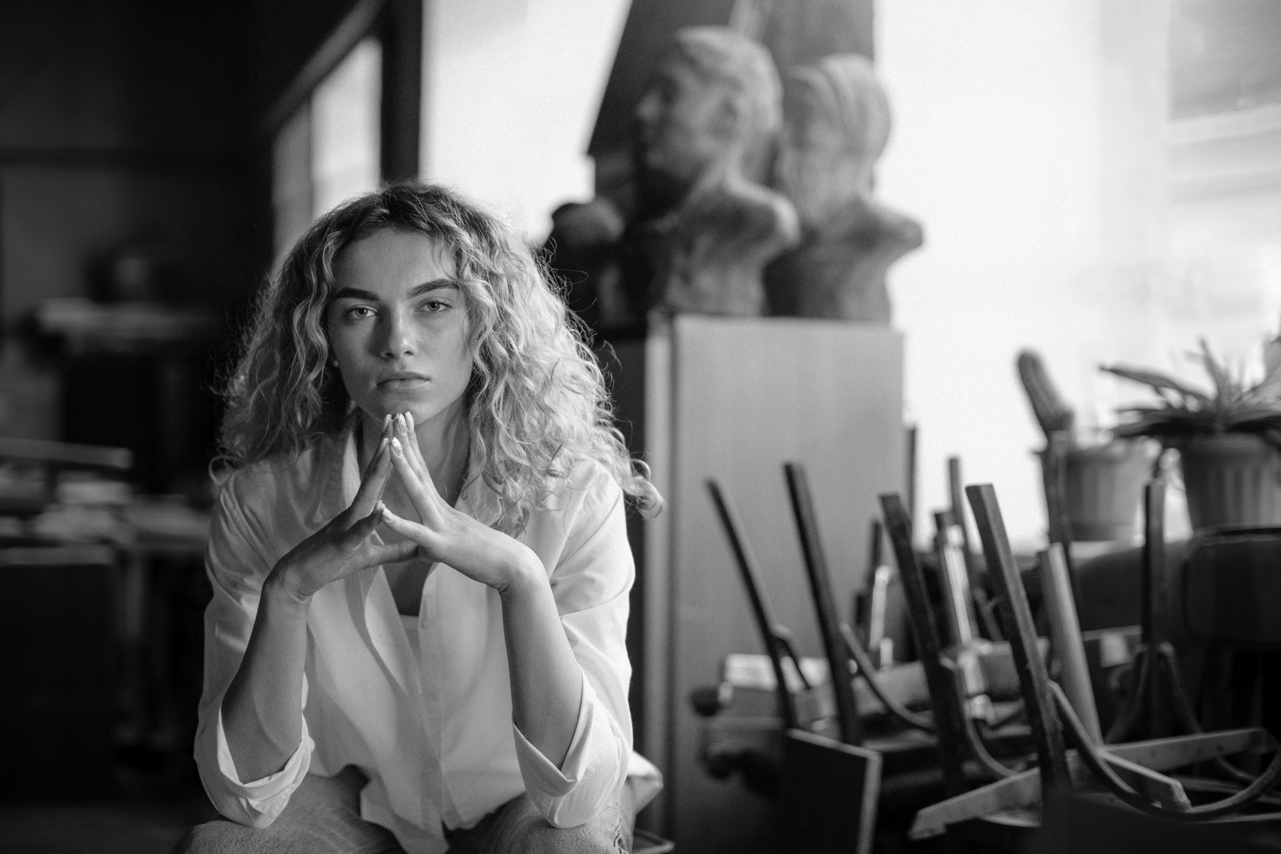 Blonde woman in an off-shoulder top working on a laptop.