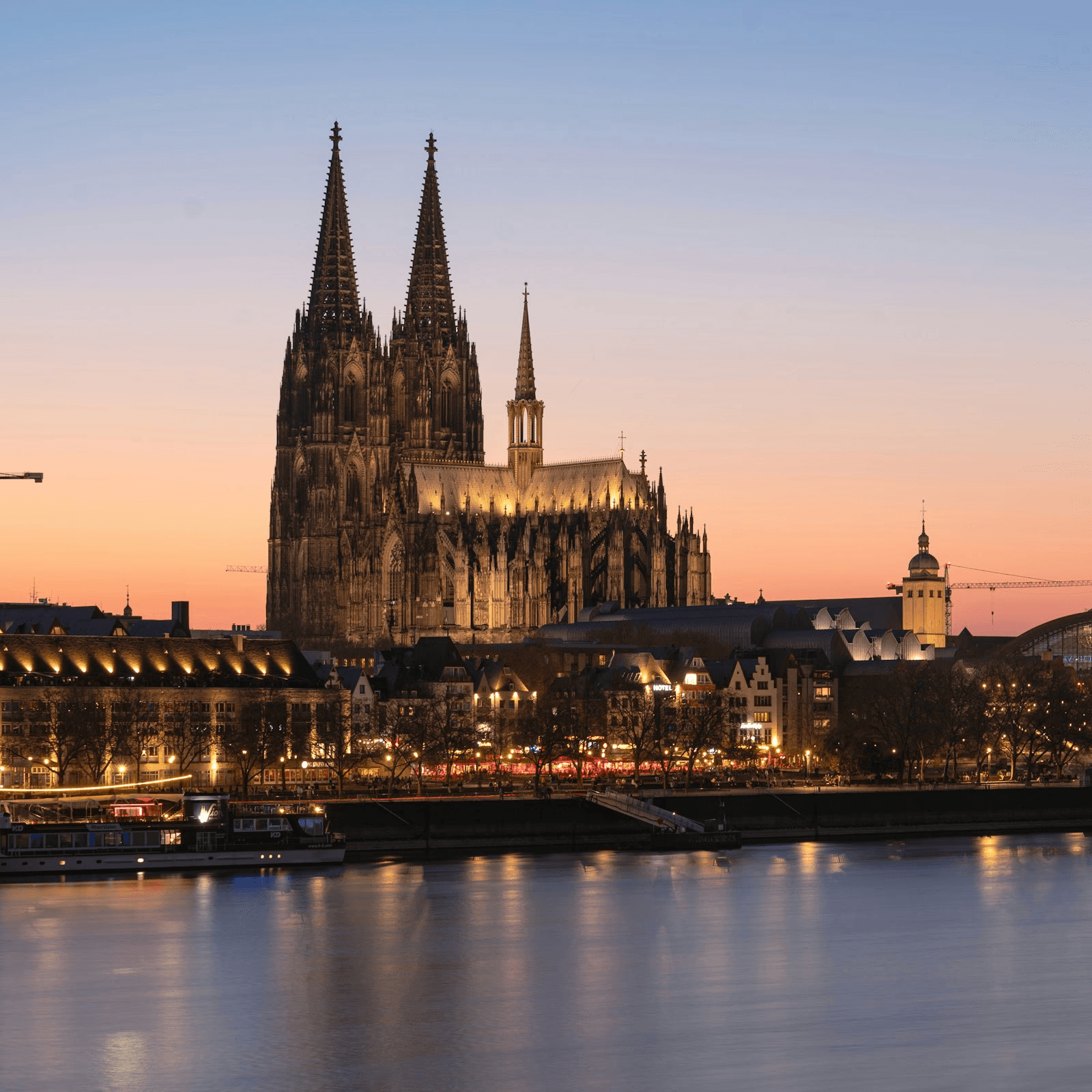 Abendaufnahme des Kölner Doms mit Blick über den Rhein – Symbolbild für die regionale Verbundenheit von AS Projekte und den Immobilienstandort Köln.