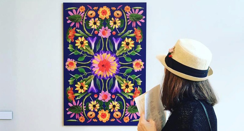 person looking at a vivid colored flower poster