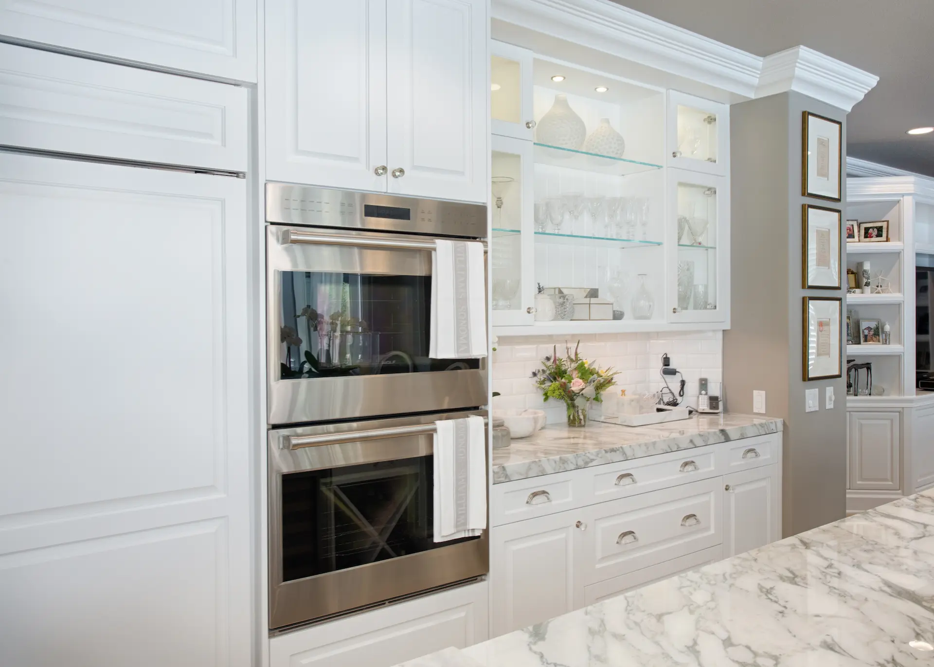 'Newport Beach Remodel' detailed kitchen view with built-in stainless steel ovens and glass-fronted cabinets.