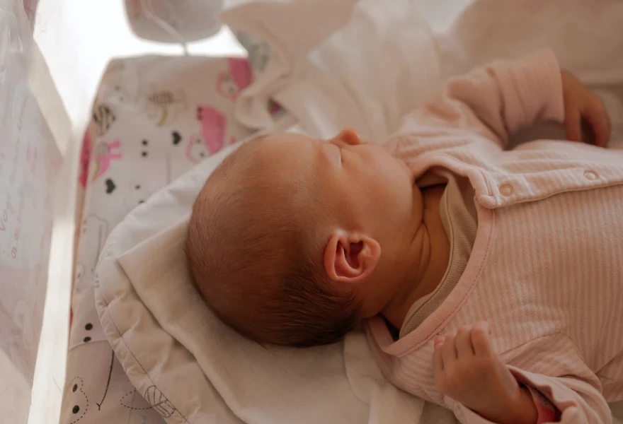 Novorozenec v postýlce v porodnici