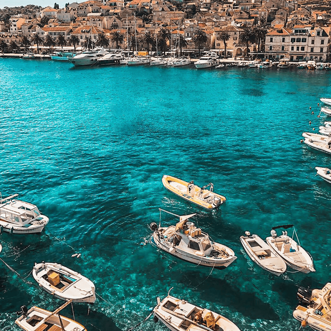 Petits bateaux au mouillage dans les eaux turquoise d’un port croate, décor paisible et lumineux pour une retraite en Dalmatie
