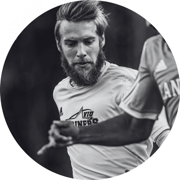 Close up photo of a soccer player mid game with a beard.