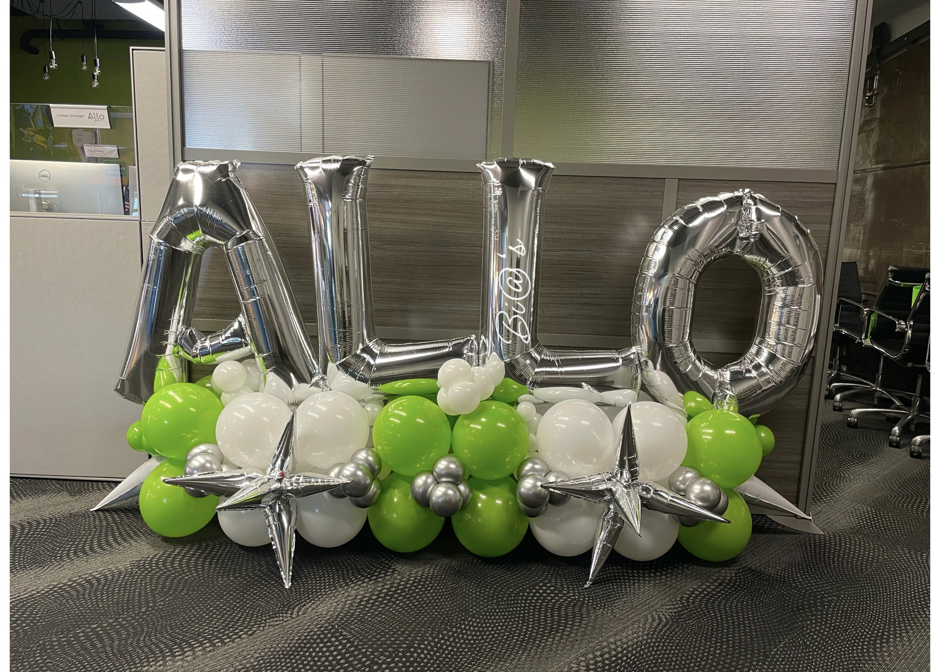 Custom balloon arrangement with silver letters and green, white, and silver balloon clusters. Susa’s Sweets & Balloons.