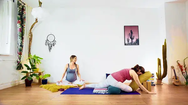 Pregnant woman in a ground-based restorative yoga pose – prenatal yoga class to calm the nervous system and release tension for better sleep during pregnancy