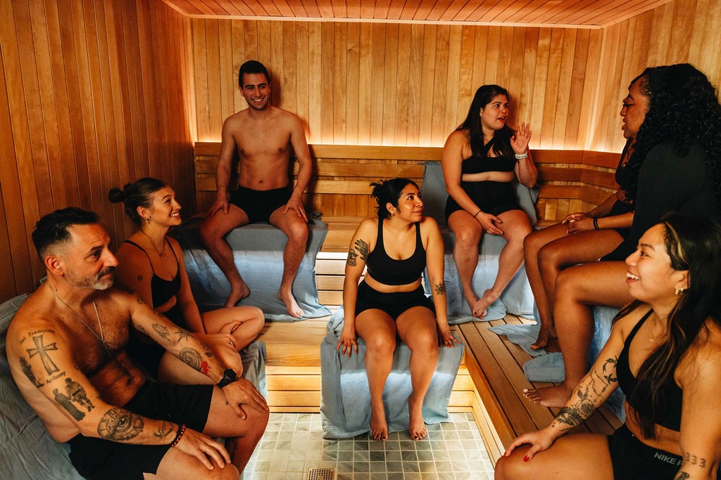 A group of people in a wooden finnish sauna enjoying conversation