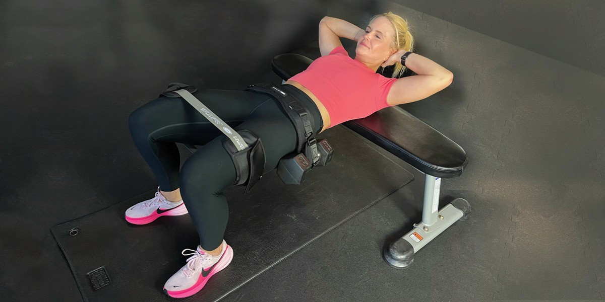 Female athlete performing the Jacked Ass Method™ strength training using specialized equipment to focus on controlled time under tension.