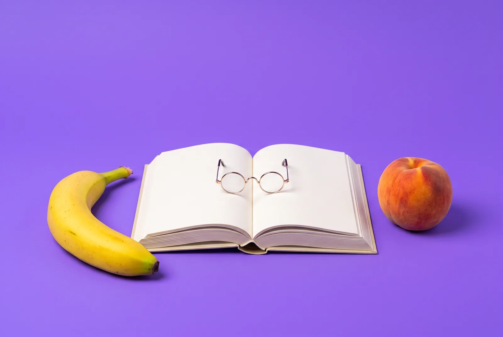 A banana and a peach beside an open book with reading glasses, what research says when your boyfriend watches porn