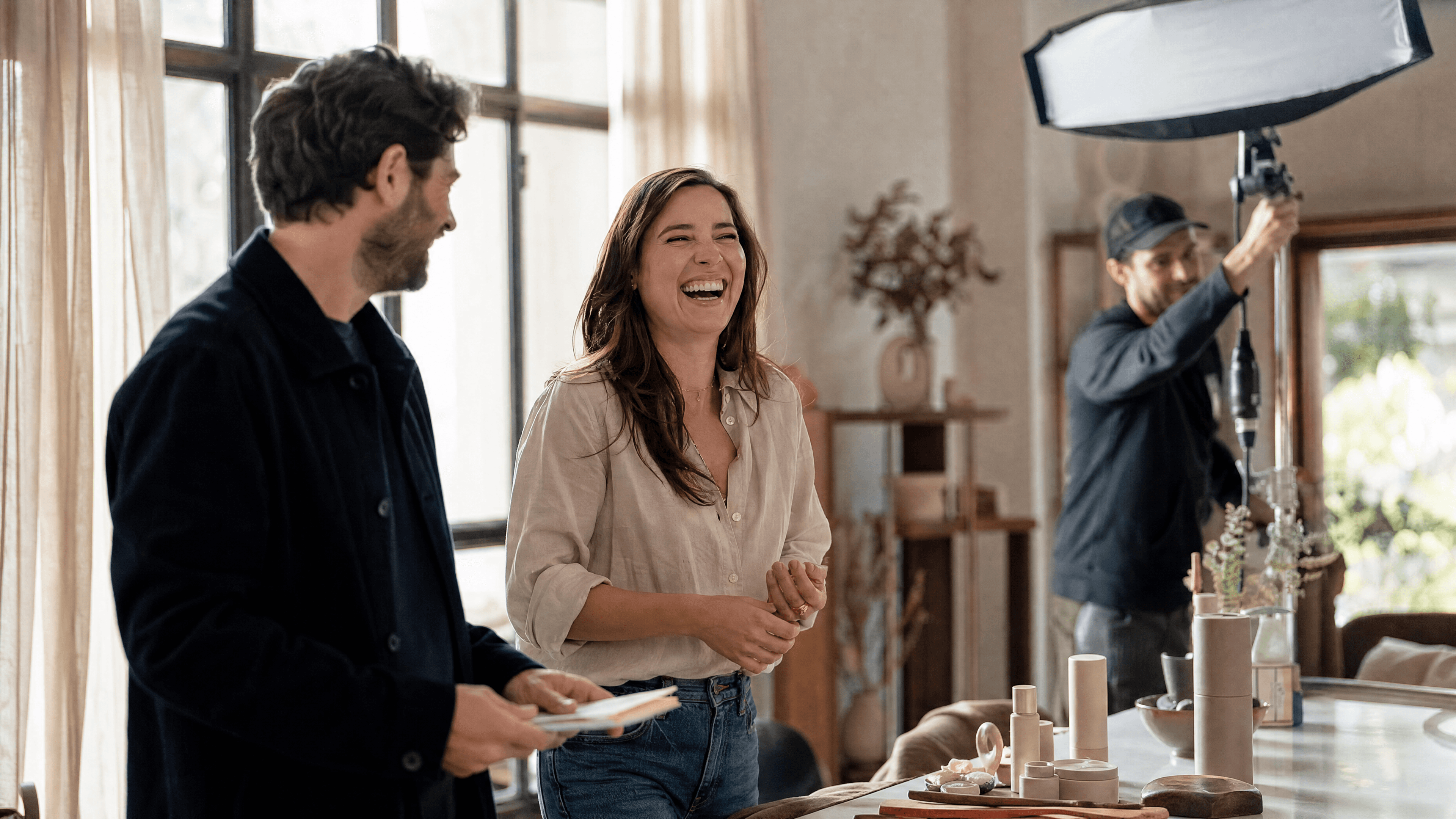 Founder laughing during a brand film shoot while a crew member adjusts the studio lighting